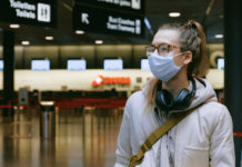 5 Steps You Can Take to Make Sure You Travel Safely woman in airport wearing face mask