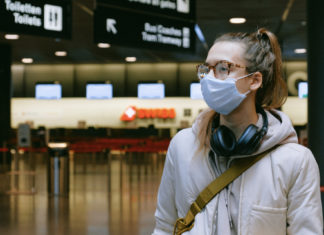 5 Steps You Can Take to Make Sure You Travel Safely woman in airport wearing face mask